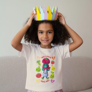 Black girl, age 5, wearing a natural colour cotton T-shirt with Miss Cutesy Meluna printed on the front, smiling confidently