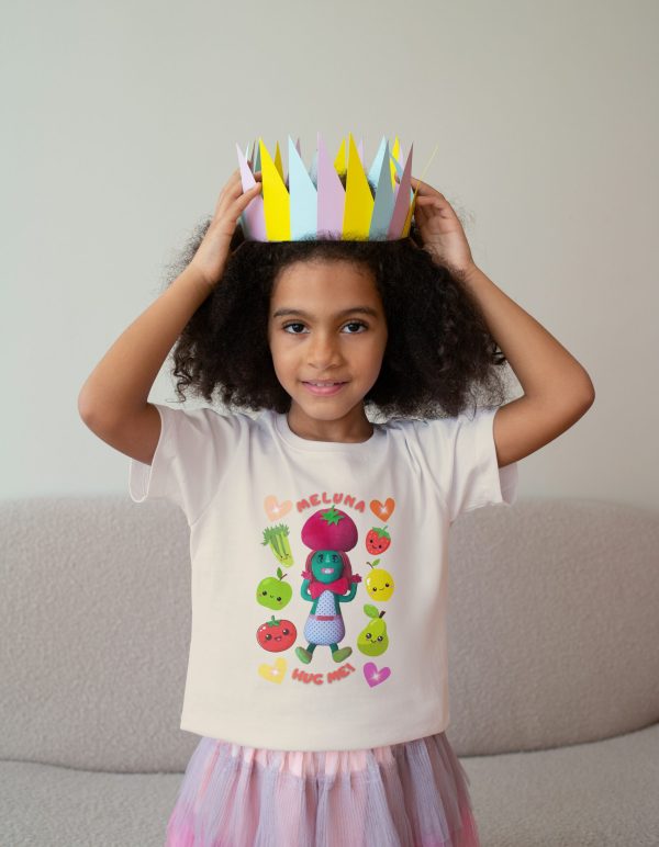 Black girl, age 5, wearing a natural colour cotton T-shirt with Miss Cutesy Meluna printed on the front, smiling confidently
