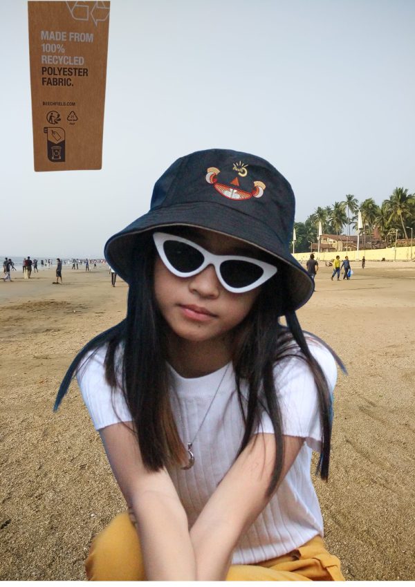 Girl wearing a Myllo bucket hat and sunglasses at the beach during holiday season